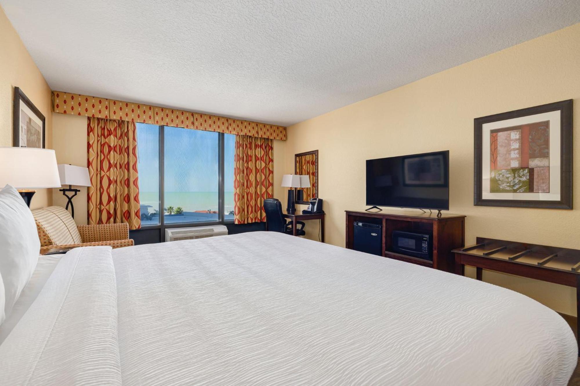 Zimmer mit Kingsize-Bett und seitlichem Blick auf das Wasser